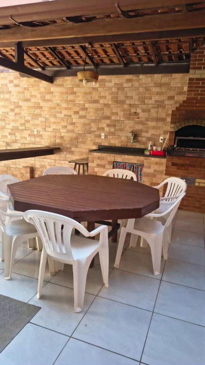 Área gourmet com mesa, cadeiras e churrasqueira